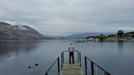 A man standing near lake Wanaka New Zealand