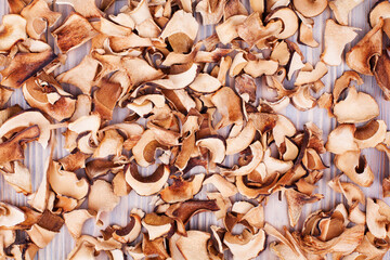 Edible dried mushrooms wooden background close up top view, dry boletus edulis texture, chopped brown cap boletus wallpaper, sliced penny bun pattern, cep pieces, porcino, porcini, cutted white fungus