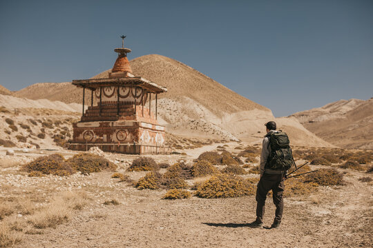 Upper mustang - Kingdom of Lo. Trekking in ancient Tibet. Sandstone massif in Nepal. Anapurna area. wild place.close territory. man backpacker in the mountains explores ancient architecture