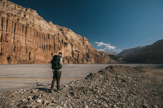 Upper mustang - Kingdom of Lo. Trekking in ancient Tibet. Sandstone massif in Nepal. high quality photo. Anapurna area. wild place.close territory. man backpacker in the mountains enjoys the view