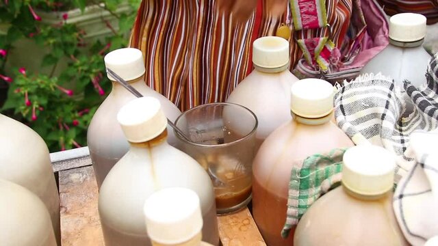 Traditional herbal medicine seller when brewing jamu or herb drink in a glass, Pekalongan Indonesia,