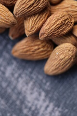 Almond nut close-up on a gray  shabby background.Vegetarian and vegan food.  Healthy fats ingredient. Wholesome food and snack.