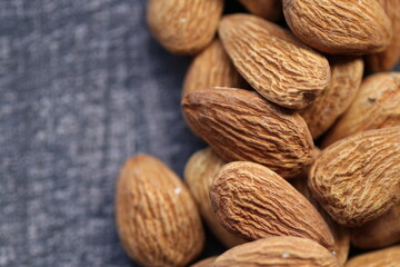 Almond nut close-up on a gray wooden shabby background.Vegetarian and vegan food.  Healthy fats ingredient. Wholesome food and snack.