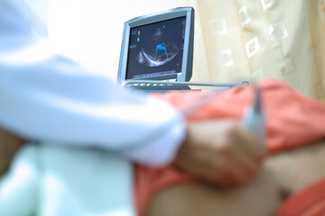 Physician making echocardiography for male patient heart, focus screen of echocardiography machine