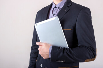 Man in business suit holding a tablet.