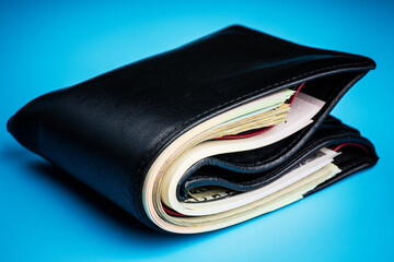 leather wallet with money on blue background