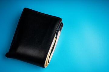 leather wallet with money on blue background