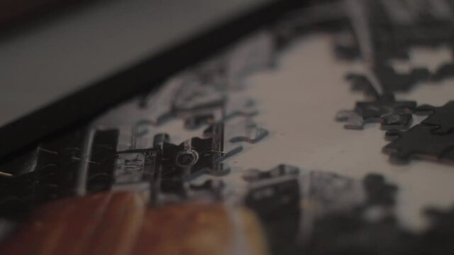 Some footage showing a hand adding a piece to an uncomplete puzzle.