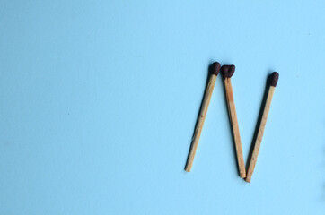 Scattered matches stick on a blue background with copyspace. Top view.
