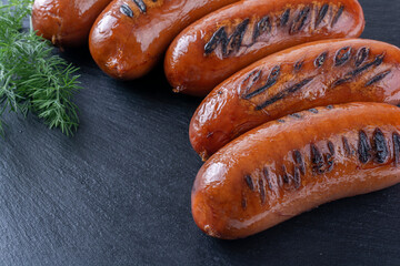 grilled sausages on a stone tray, top view