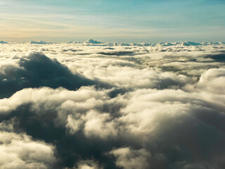 A view from window of an airplane above thick clouds formation