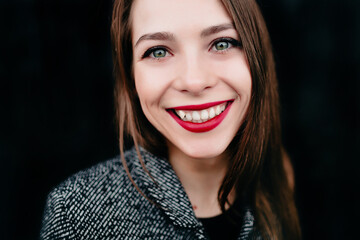 Pretty lady in festive dress points to place for text on black background