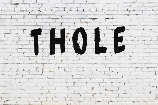 White wall with black paint inscription thole on it