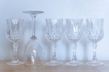 A group of luxury glass sit on the wodden table in front of white concrete wall