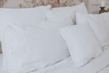 several beautiful white pillows lie on the bed