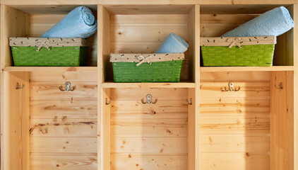 wooden shelving unit and baskets with clean towels 
