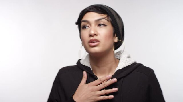 Portrait of a young woman of Middle Eastern descent feeling scared and anxiety on a white studio backdrop