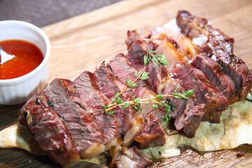 Delicious steak. Beef steak on wooden plate. Medium-roasted steak on a wooden board with sauce. 