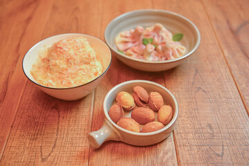 Sweet khinkali with cherry, Cookies called nuts with condensed milk and Cake Napoleon served in white plates.