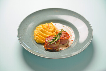 Beef meat pieces with mashed potato, onion gravy and spices. Served on a blue plate over blue mint background.