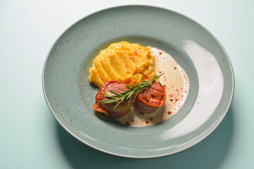 Beef meat pieces with mashed potato, onion gravy and spices. Served on a blue plate over blue mint background.