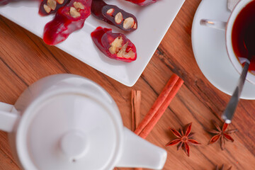 Tasty oriental sweets. Caucasian delicacy churchkhela - georgian nut treats. Served with a glass of tea and a tea pot.
