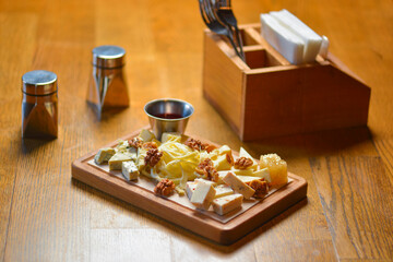 Different sort of farm made cheese served on a wooden board. Cheese platter with different kinds of cheese.