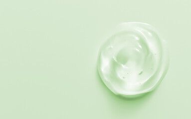 Cosmetic gel drop. Hand sanitizer, alcohol gel blob on pastel green background. Transparent cream...