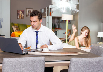 Man with cup of coffee using laptop