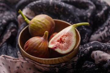 Fresh ripe figs in a bowl closeup on a dark background