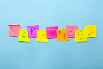 Papers with word HAPPINESS on color background