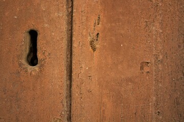 evocative texture image of an old wooden door with vertical axes and lock