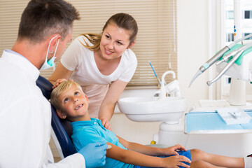 Woman with boy are visiting dentist