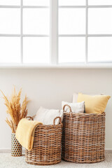Fototapeta premium Wicker baskets with pillows and plaid in room