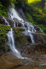 Fototapeta na wymiar Waterfall landscape. Beautiful hidden Goa Giri Campuhan waterfall in tropical rainforest in Bali. Nature concept. Slow shutter speed, motion photography.