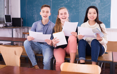 Happy students with notebooks during break in auditorium