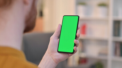 Rear View of Man using Smartphone with Chroma Key Screen 