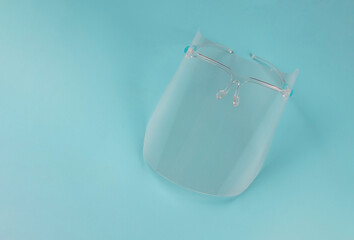COVID-19 prevention and new normal lifestyle concept. Top view of face shied  on blue background...