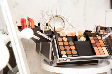 Case of professional makeup artist with decorative cosmetics on table