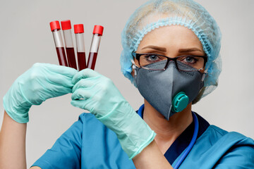 medical doctor nurse woman wearing protective mask and gloves - holding virus blood test tube