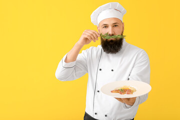 Handsome male chef on color background