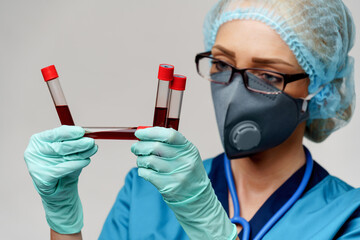 medical doctor nurse woman wearing protective mask and gloves - holding virus blood test tube