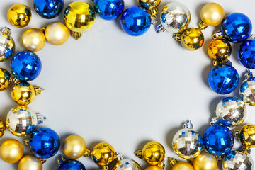 frame of gold, silver and blue Christmas balls on a gray background, Christmas background. New Year or Christmas decorations.