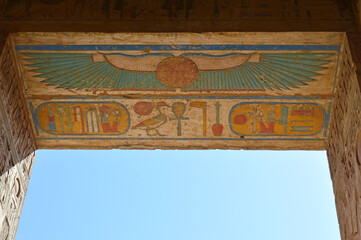 Coloured ancient Egyptian hieroglyphs on the ceiling of a doorway inside a temple in Luxor, Egypt