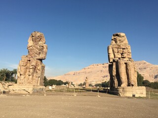 Collosi of Memnon giant ancient Egyptian statues in early morning with no tourists in Luxor, Egypt