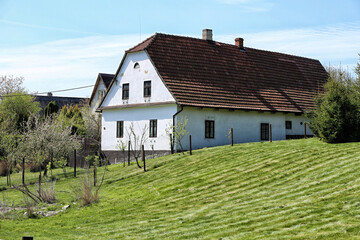 Fototapeta na wymiar Traditional Moravian house with green hilly garden