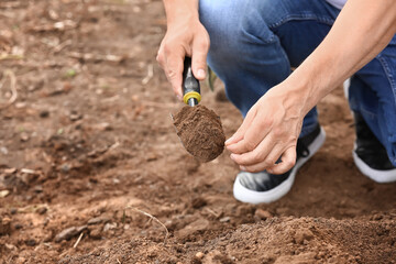 Man testing rich soil outdoors