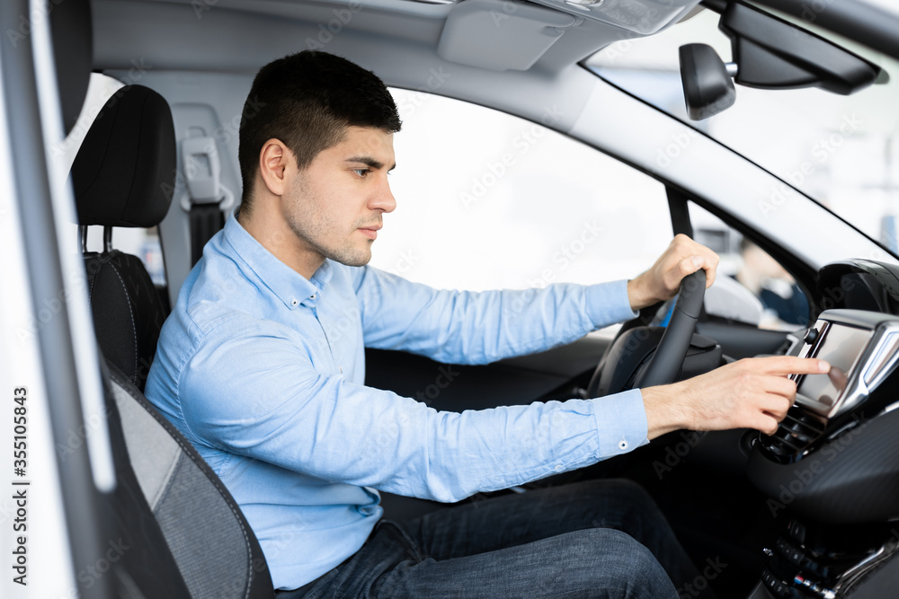 Poster businessman sitting in new auto checking navigation system
