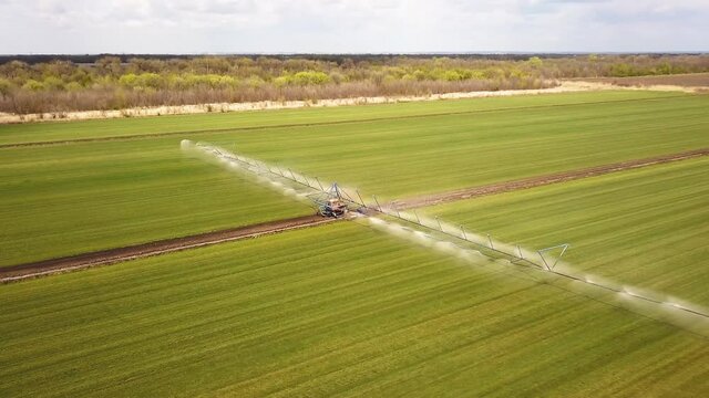 Farm tactor spraying agricultural fields.