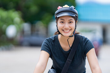 Asian women ride bicycles to work.